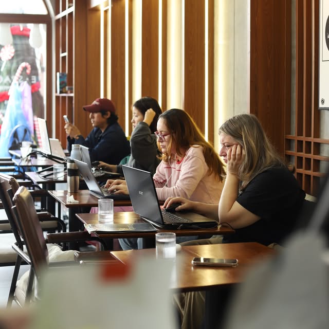 Guests working and catching up over coffee inside E-Space